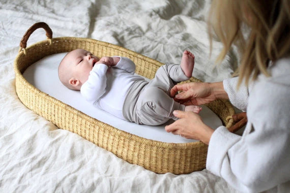 baby in Ghana Moses basket with pink fitted sheet