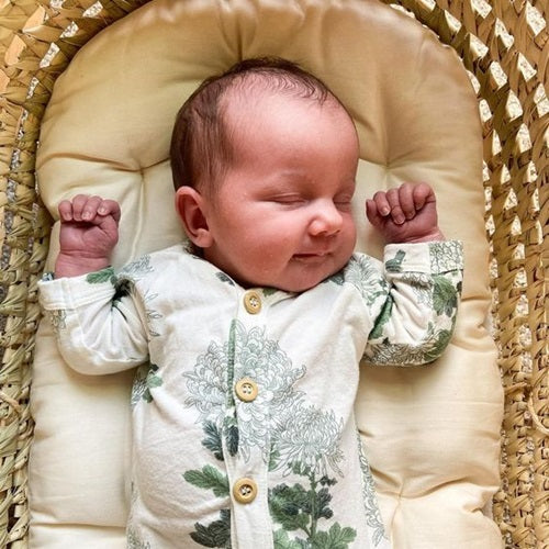 baby laying on organic cotton futon in a Moses basket by Wendy Anne