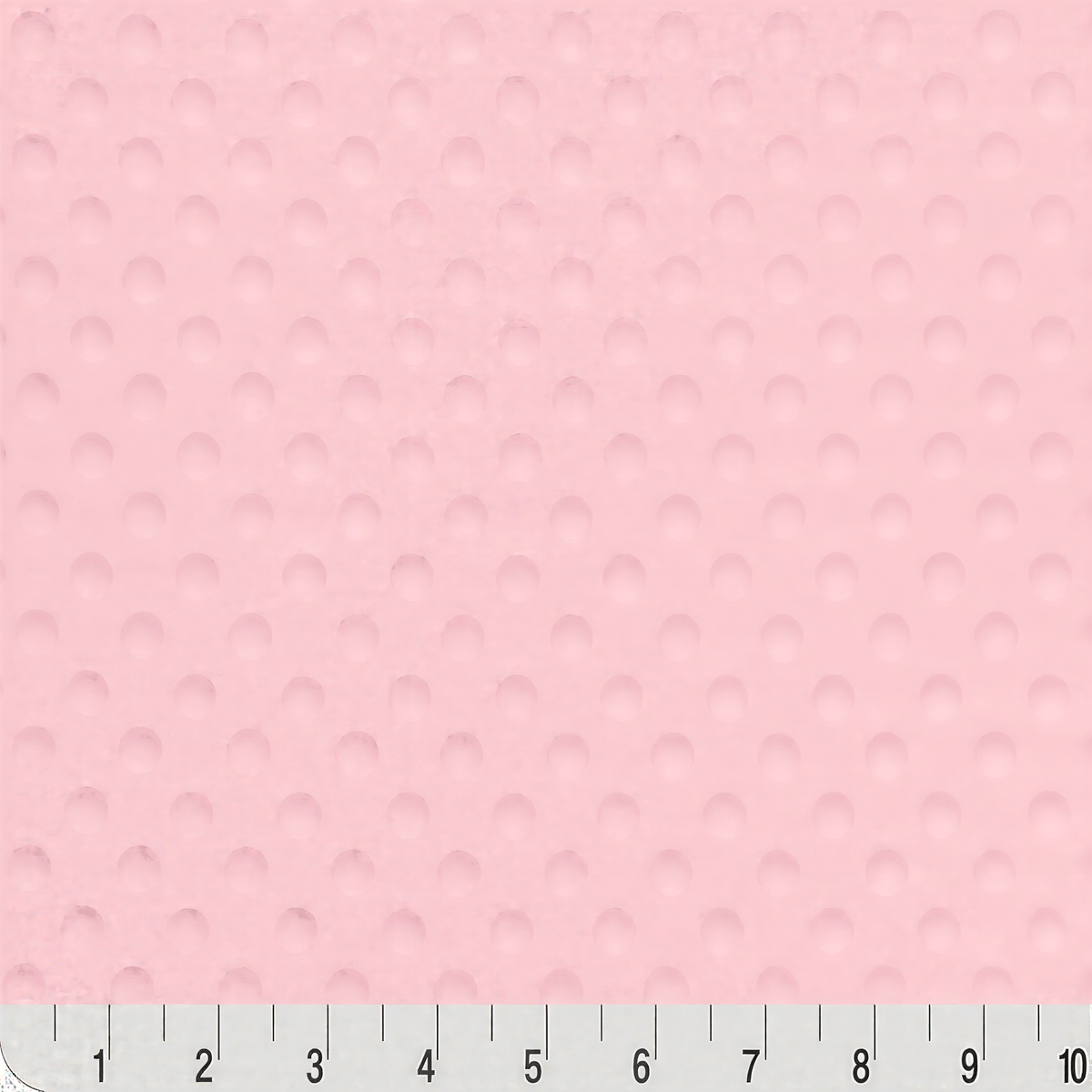 The image is a close-up of a pink fabric with a textured surface, and there is a ruler at the bottom of the image for scale.