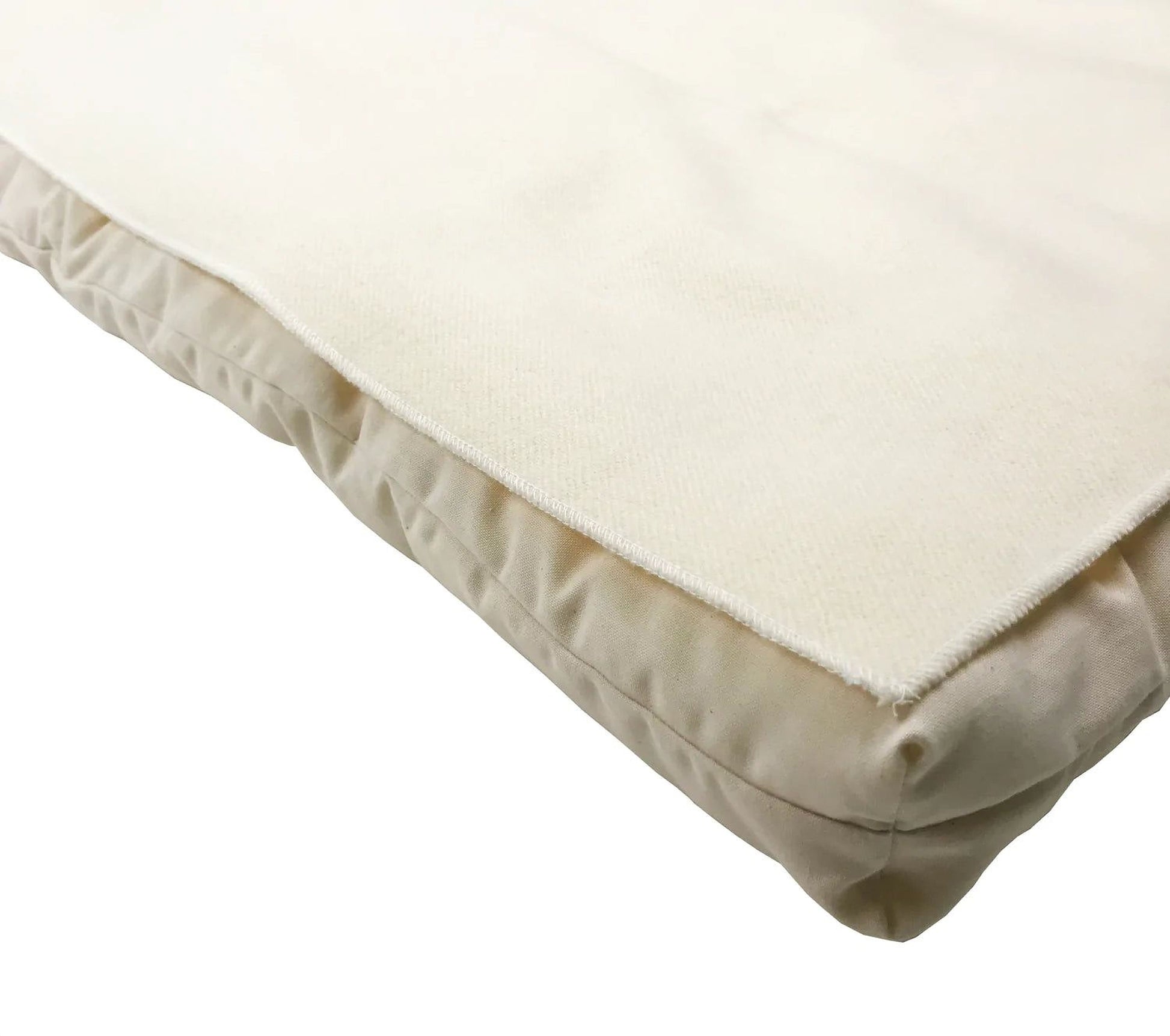 A close-up view of a beige, soft-looking fabric, possibly a blanket or cushion, with a slightly wrinkled texture.