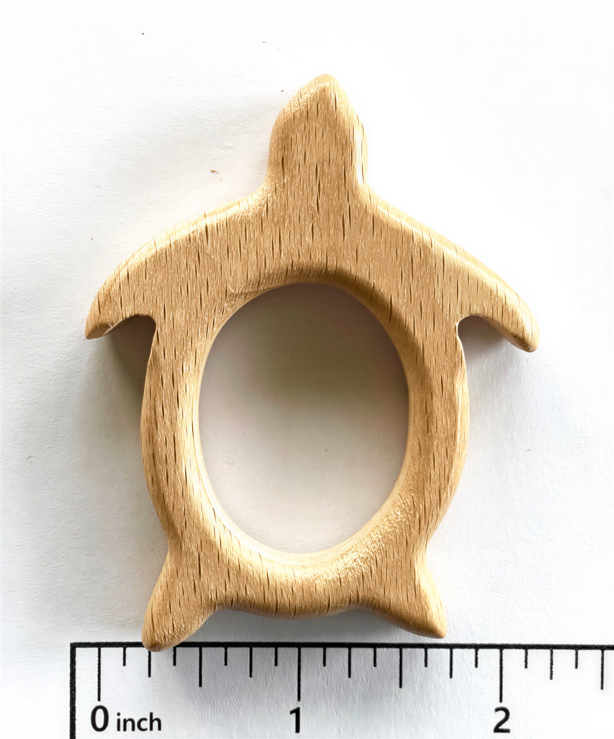 A wooden turtle-shaped object is shown next to a ruler for size comparison.