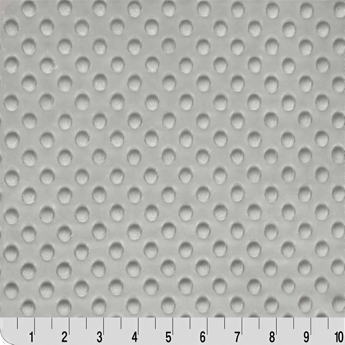 a close-up view of a surface with a repeating pattern of small white circles or dots, creating a textured or perforated appearance.