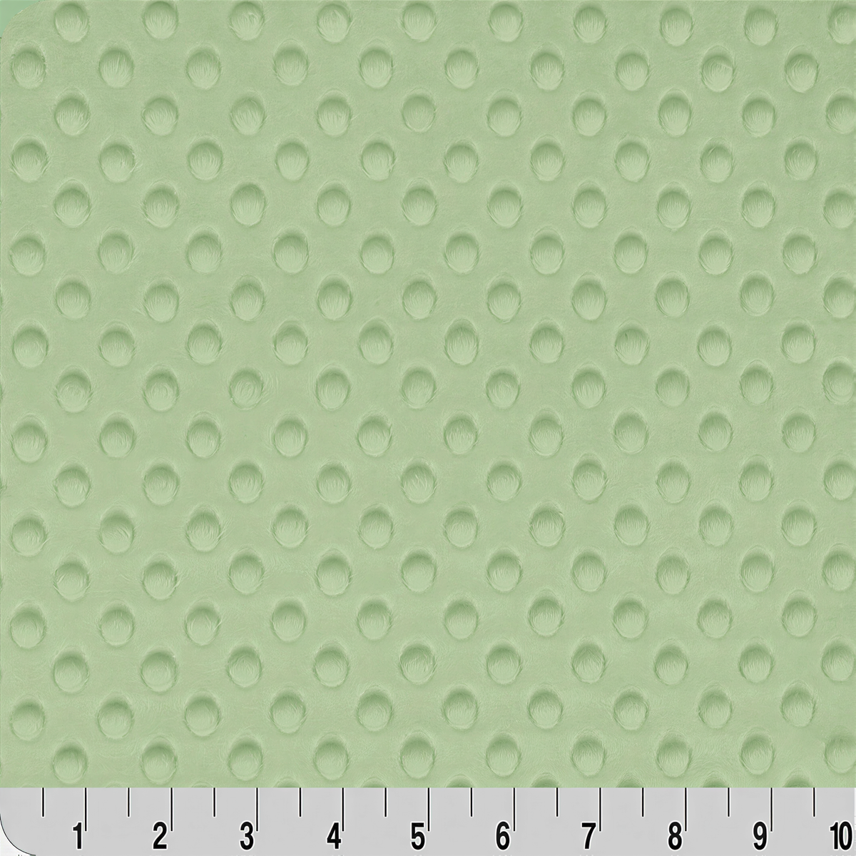 a close-up view of a fabric with a green polka dot pattern. The fabric appears to be a soft, textured material with a repeating pattern of small circles. The image does not contain any text or other objects, and the focus is solely on the fabric's texture and color.