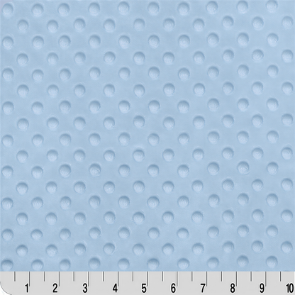 a close-up view of a fabric with a light blue color and a pattern of small white circles or dots. The fabric appears to be soft and textured, suitable for use as a material for clothing or other textile products.