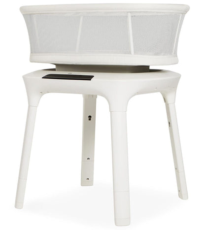 A white, modern-looking crib or bassinet with a mesh cover, designed for newborns or young children.
