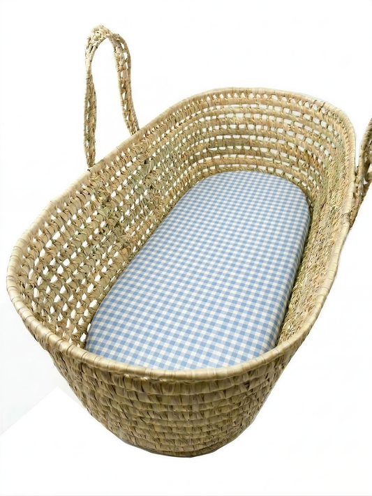 A woven basket with a blue and white checkered cloth inside.