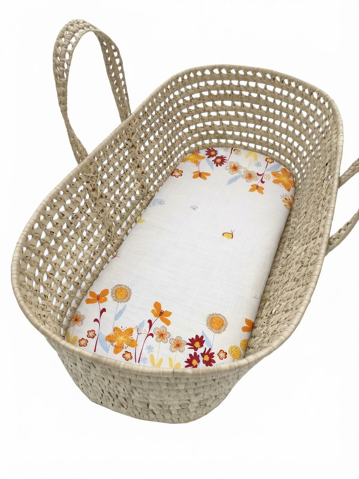 A woven basket with a floral pattern on the side and a white sheet with a floral pattern inside.